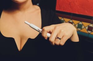 Personne échangeant avec un perceur professionnel avant la pose d’un piercing au téton dans un studio spécialisé.
