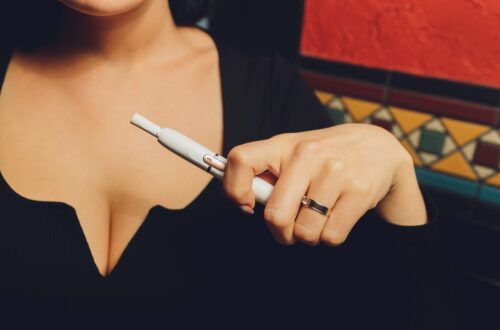 Personne échangeant avec un perceur professionnel avant la pose d’un piercing au téton dans un studio spécialisé.